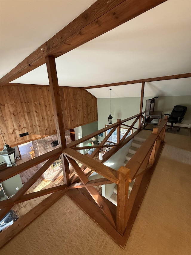 staircase with vaulted ceiling with beams and wood walls