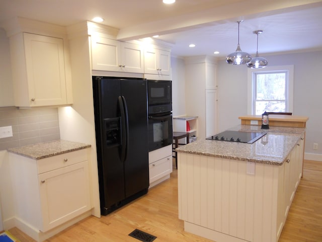 kitchen with black appliances, white cabinets, hanging light fixtures, decorative backsplash, and light stone counters