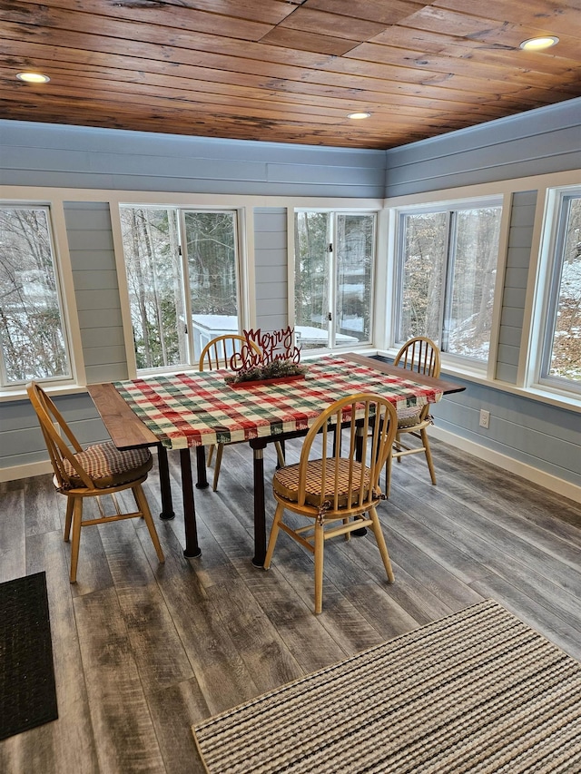 dining room with a healthy amount of sunlight, dark hardwood / wood-style flooring, and wood ceiling