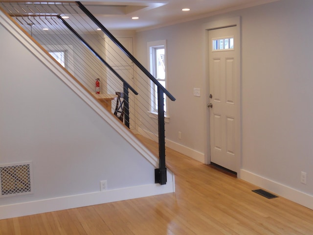 entrance foyer with crown molding and light wood-type flooring