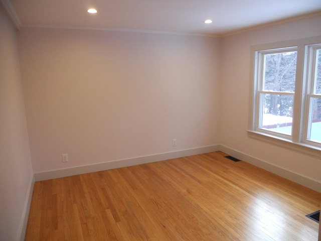 spare room with light wood-type flooring and ornamental molding