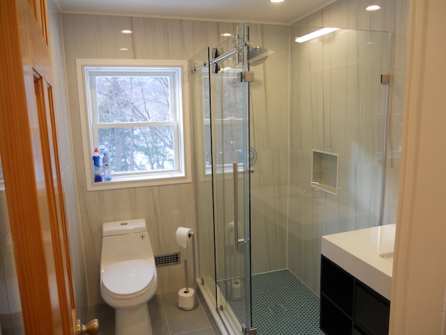 bathroom featuring tile patterned floors, vanity, toilet, and a shower with shower door