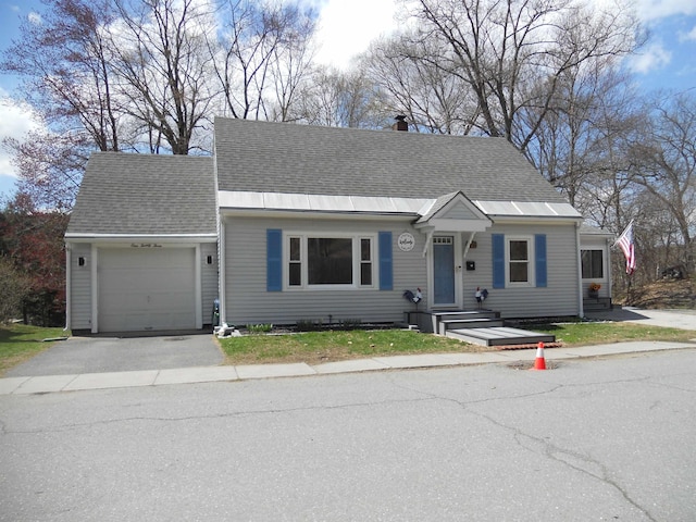 123 Commonwealth Ave, Springfield, VT 05156 - view of front of property featuring a garage, driveway, roof with shingles, and a chimney