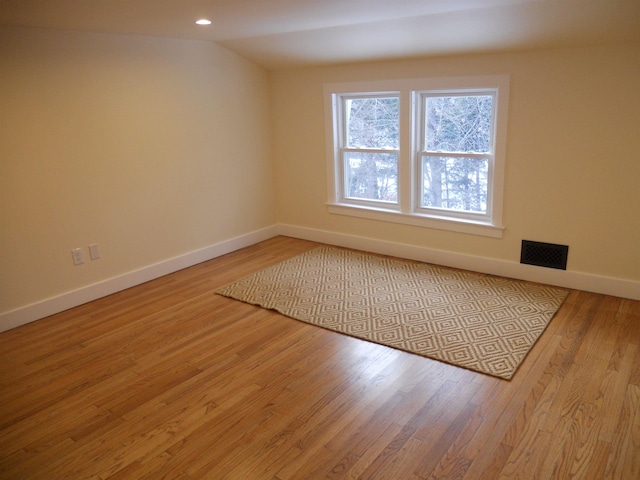 unfurnished room featuring light hardwood / wood-style floors and vaulted ceiling