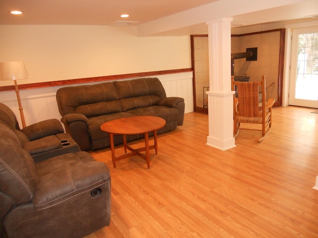 living room with light wood-type flooring and ornate columns