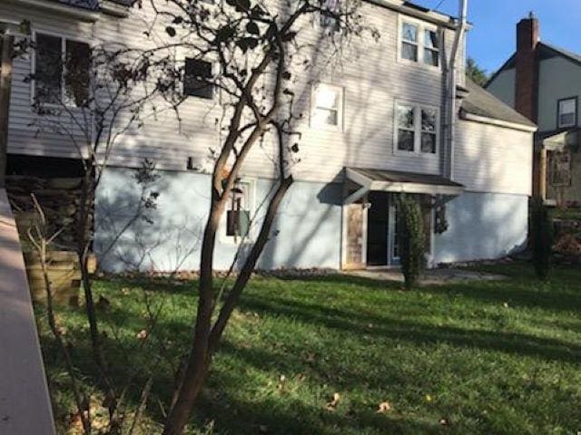 rear view of house featuring a lawn