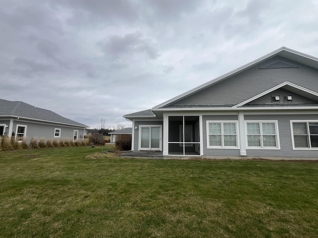 rear view of property featuring a lawn