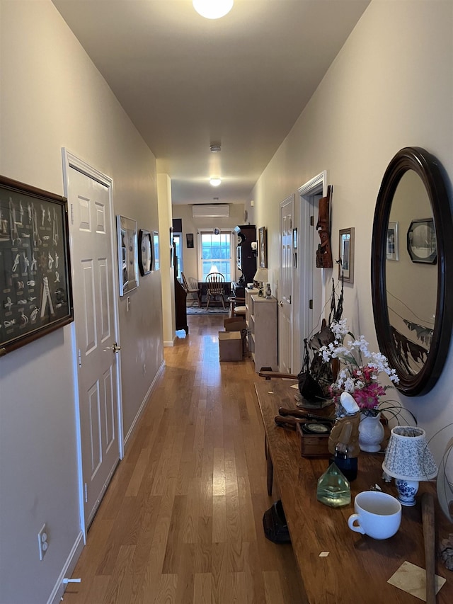 hallway with an AC wall unit and wood-type flooring