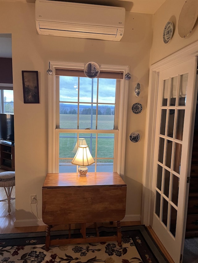 room details featuring a wall mounted AC, a water view, and hardwood / wood-style flooring