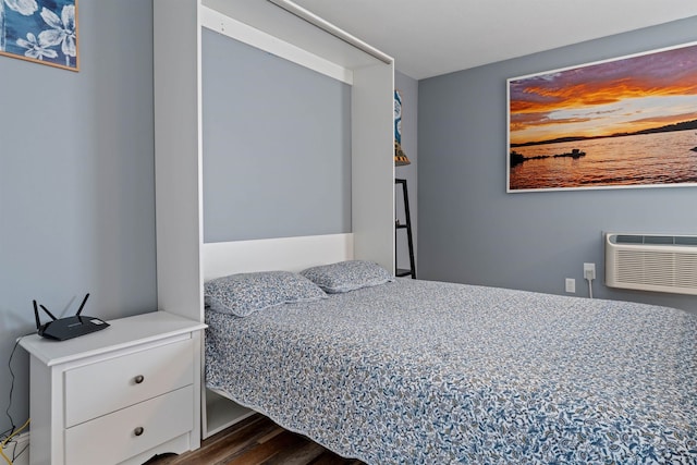 bedroom featuring a wall unit AC and dark wood-type flooring