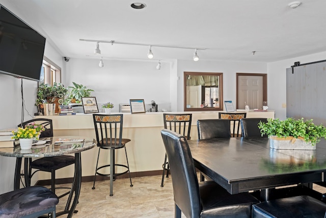 dining space featuring a barn door and track lighting