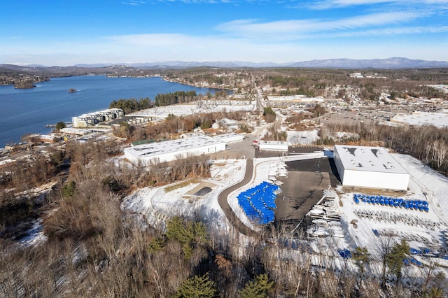 snowy aerial view featuring a water and mountain view