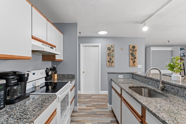 kitchen with white cabinets, light hardwood / wood-style flooring, white range with electric cooktop, and sink