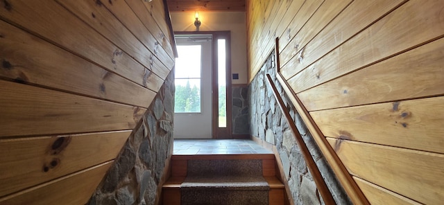 stairs featuring wood walls