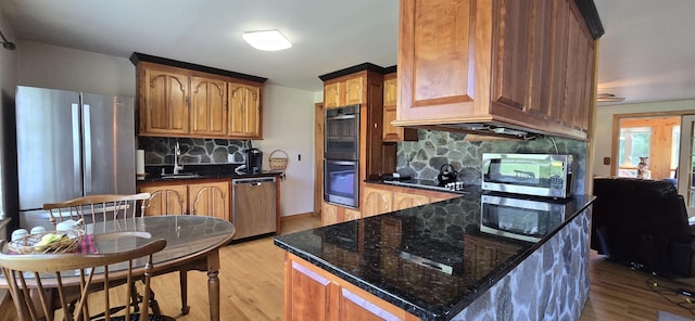 kitchen featuring decorative backsplash, light wood-type flooring, and appliances with stainless steel finishes