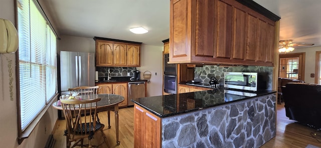 kitchen with backsplash, a healthy amount of sunlight, and appliances with stainless steel finishes