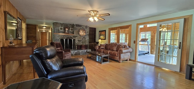 living room with ceiling fan, a fireplace, and light hardwood / wood-style flooring