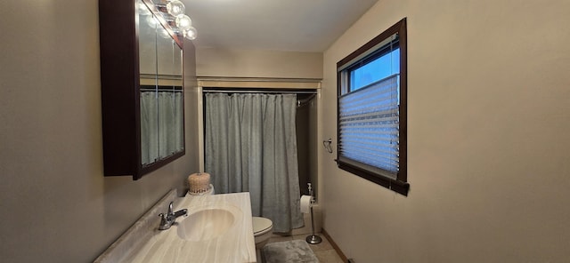 bathroom with tile patterned floors, vanity, toilet, and walk in shower