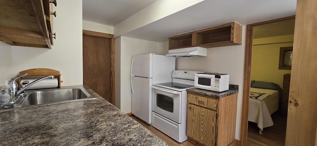 kitchen with white appliances, light hardwood / wood-style flooring, and sink