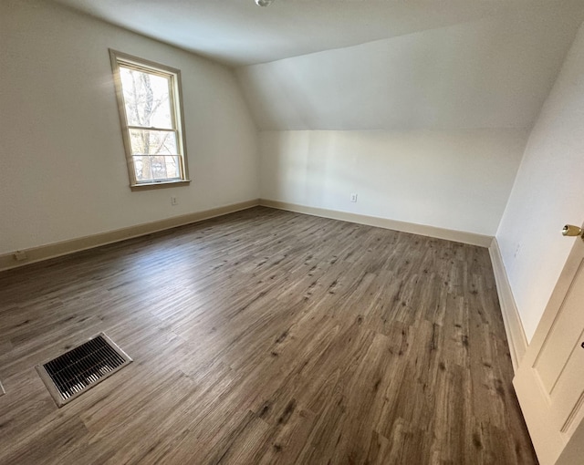 additional living space featuring hardwood / wood-style flooring and vaulted ceiling