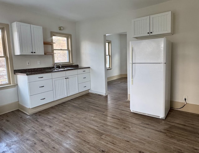 kitchen with white cabinetry, sink, wood-type flooring, and white refrigerator