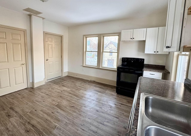 kitchen featuring white cabinets, dark hardwood / wood-style floors, black range with electric stovetop, and sink