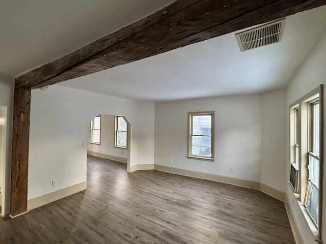 spare room with a healthy amount of sunlight and dark hardwood / wood-style flooring