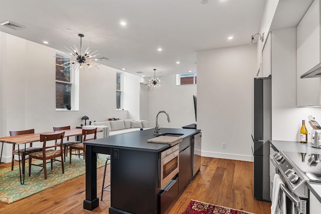 131 Main St Unit 2A-1, Burlington, VT 05401 - kitchen with stainless steel appliances, dark countertops, a chandelier, recessed lighting, and a center island with sink