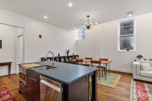 131 Main St Unit 2A-1, Burlington, VT 05401 - kitchen with dishwasher, a center island with sink, light wood-type flooring, a chandelier, and open floor plan