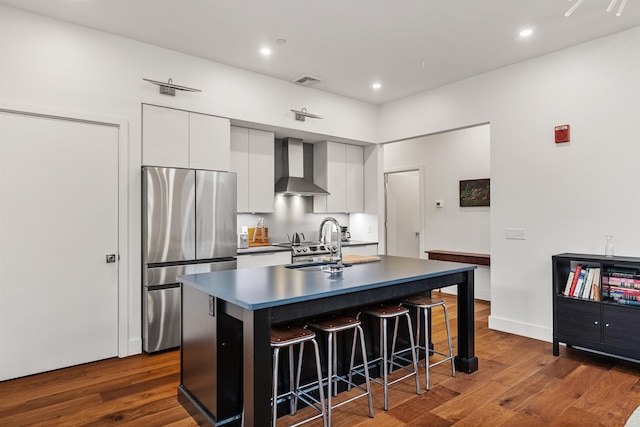 131 Main St Unit 2A-1, Burlington, VT 05401 - kitchen featuring freestanding refrigerator, wall chimney exhaust hood, dark countertops, dark wood finished floors, and a kitchen breakfast bar