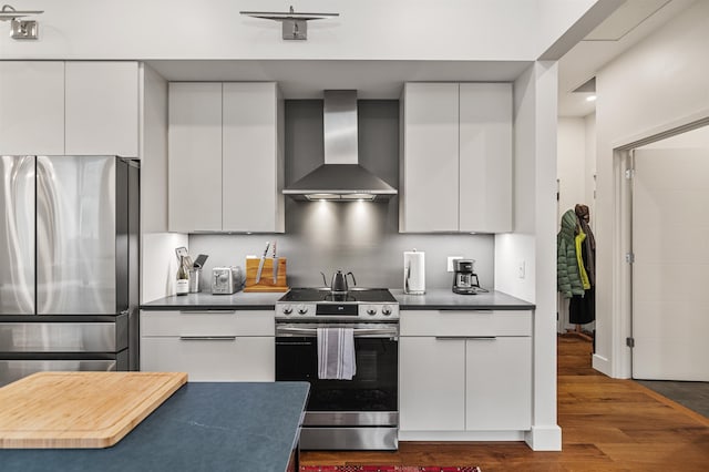 kitchen with white cabinetry, dark wood-type flooring, wall chimney exhaust hood, and stainless steel appliances