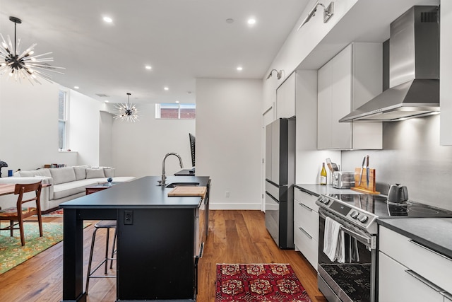131 Main St Unit 2A-1, Burlington, VT 05401 - kitchen with wall chimney exhaust hood, stainless steel electric stove, freestanding refrigerator, a chandelier, and recessed lighting