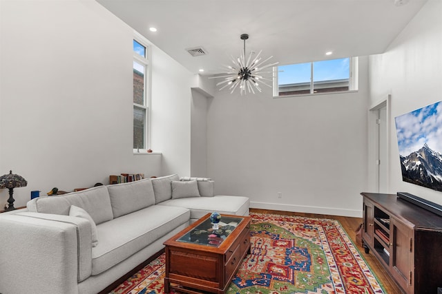 living room with hardwood / wood-style floors and an inviting chandelier