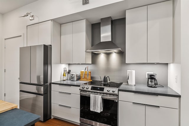 131 Main St Unit 2A-1, Burlington, VT 05401 - kitchen with wall chimney exhaust hood, stainless steel appliances, dark countertops, and white cabinetry