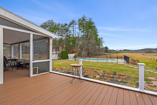 wooden terrace featuring a sunroom, a fenced in pool, and a lawn