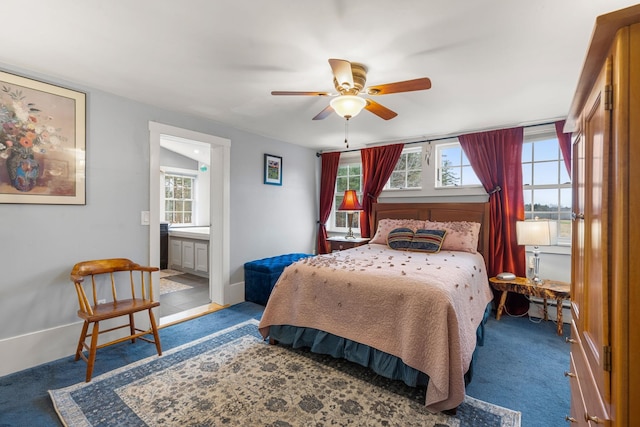 carpeted bedroom featuring multiple windows, ceiling fan, and ensuite bathroom