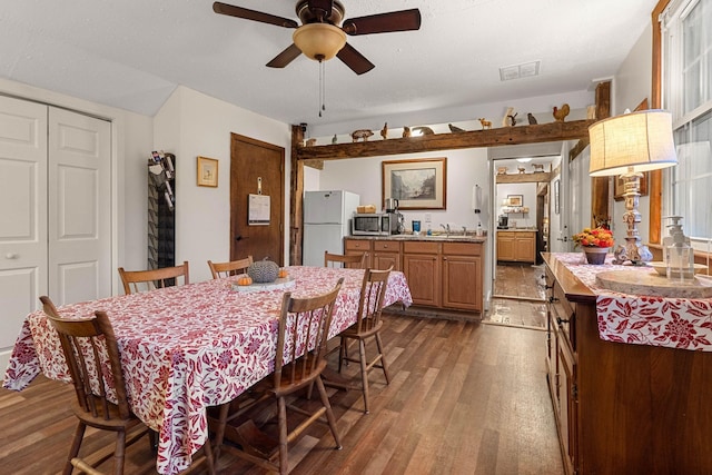 dining area with ceiling fan, sink, and wood-type flooring