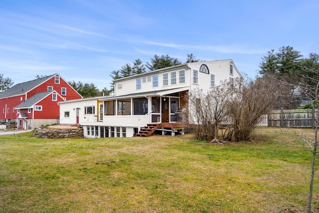 rear view of property featuring a sunroom and a yard