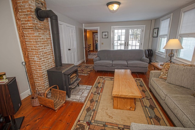 living room with hardwood / wood-style floors, a wood stove, and french doors