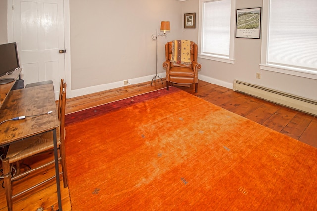 sitting room with hardwood / wood-style flooring and baseboard heating