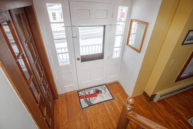 foyer entrance featuring baseboard heating and light wood-type flooring