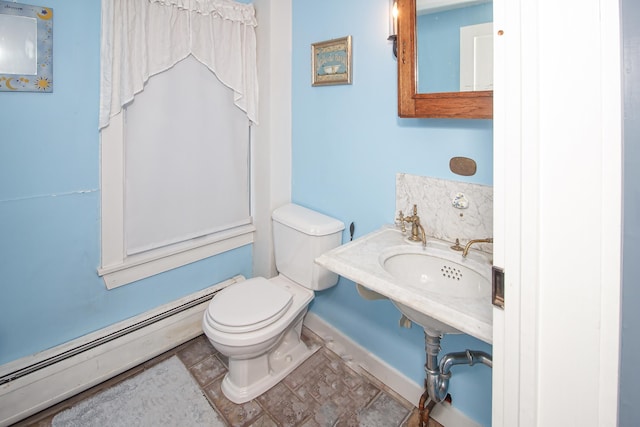 bathroom featuring toilet, baseboard heating, and sink