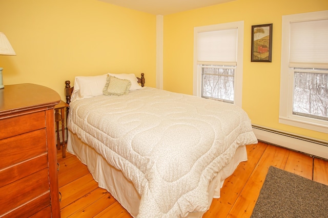 bedroom featuring light hardwood / wood-style floors and baseboard heating