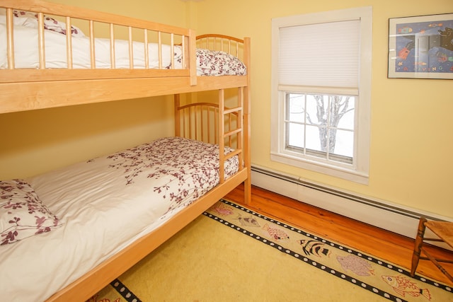 bedroom featuring wood-type flooring and a baseboard radiator