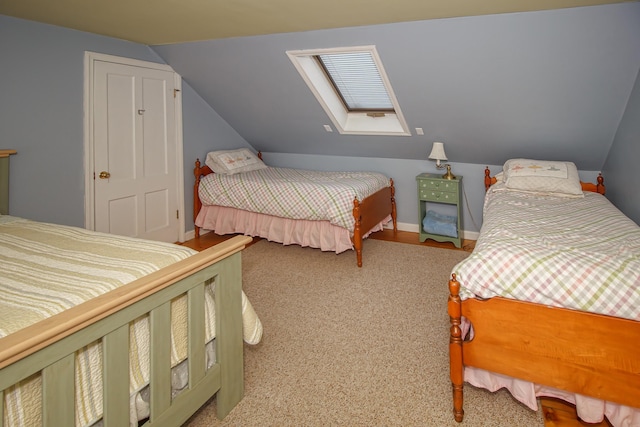 carpeted bedroom with lofted ceiling with skylight