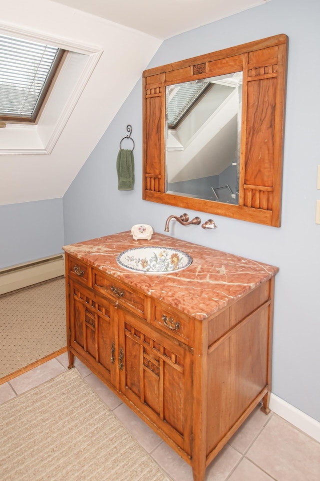 bathroom featuring tile patterned floors, vanity, lofted ceiling with skylight, and a baseboard radiator