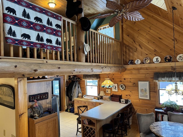 dining room featuring plenty of natural light, wood walls, wood ceiling, and ceiling fan with notable chandelier