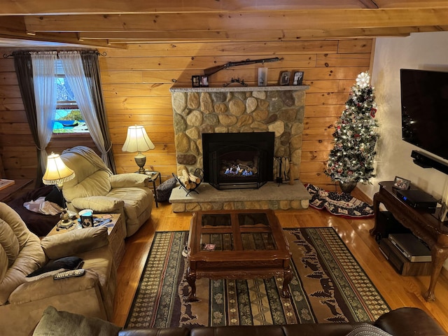 living room with hardwood / wood-style flooring, a fireplace, and beamed ceiling