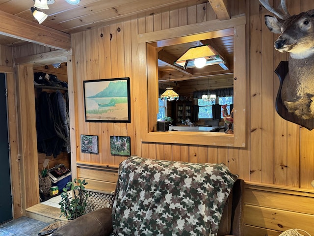 bedroom with wooden ceiling, a closet, wooden walls, and a notable chandelier