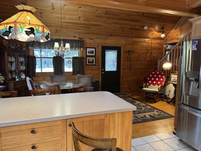 kitchen featuring stainless steel fridge with ice dispenser, a notable chandelier, wood walls, light hardwood / wood-style floors, and wood ceiling